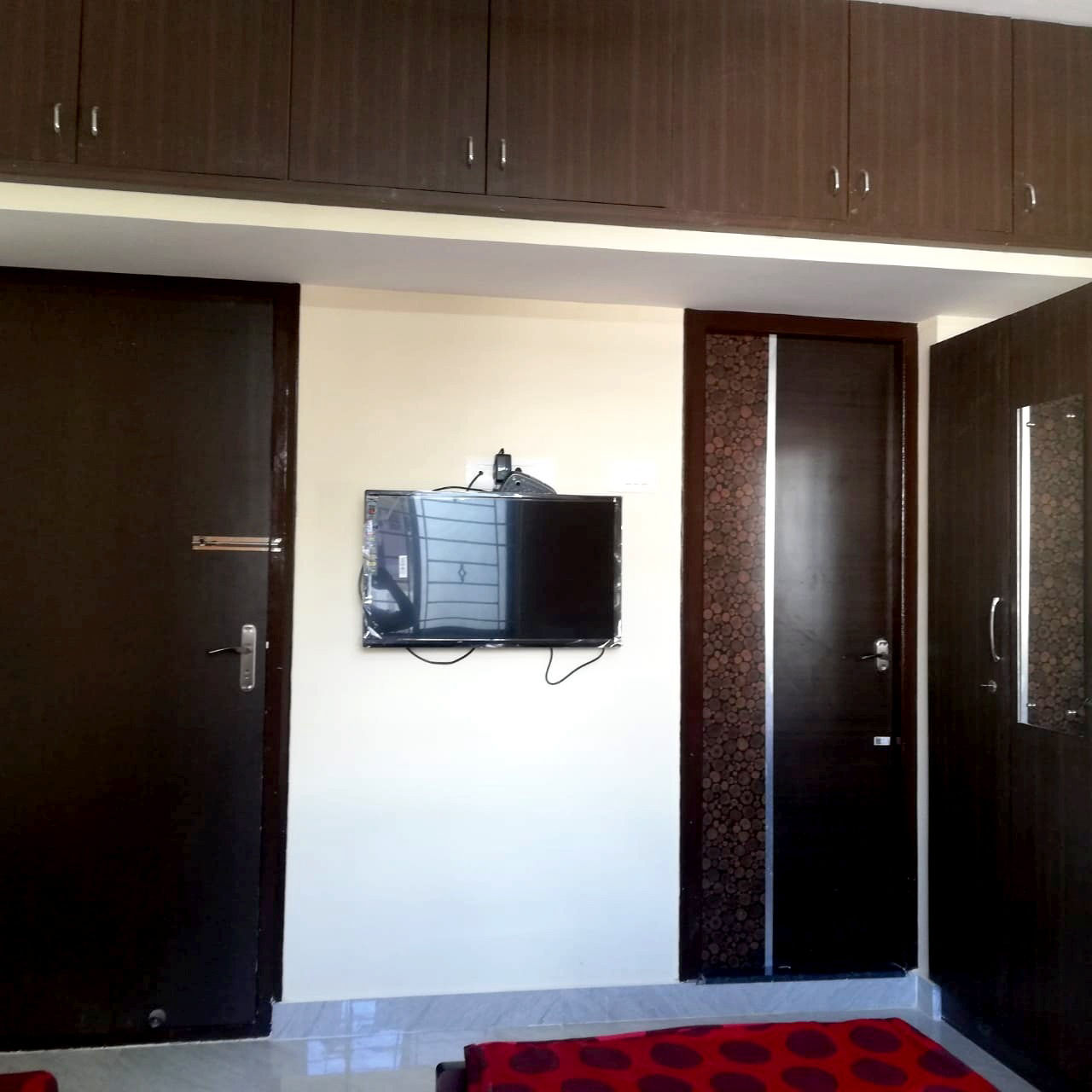 Room with wardrobes and wall-mounted TV