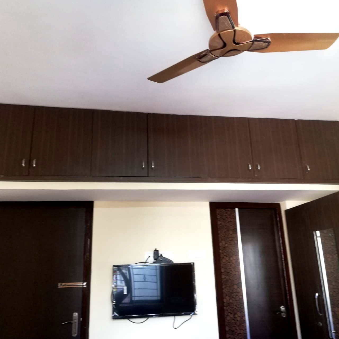 Room with ceiling fan, wardrobes and TV